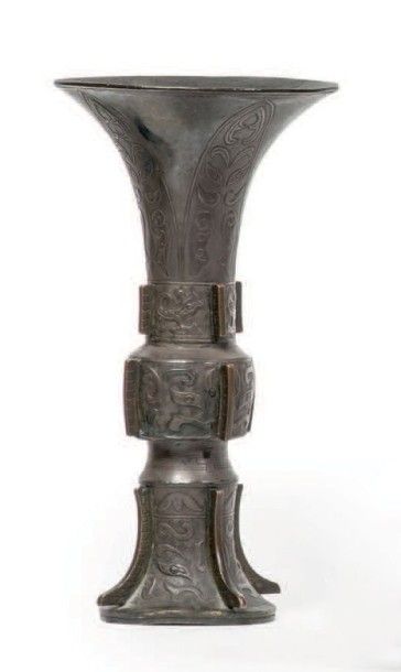 CHINE - XIXe siècle 
Vase de forme “gu” en bronze à patine brune à traces de dorure...