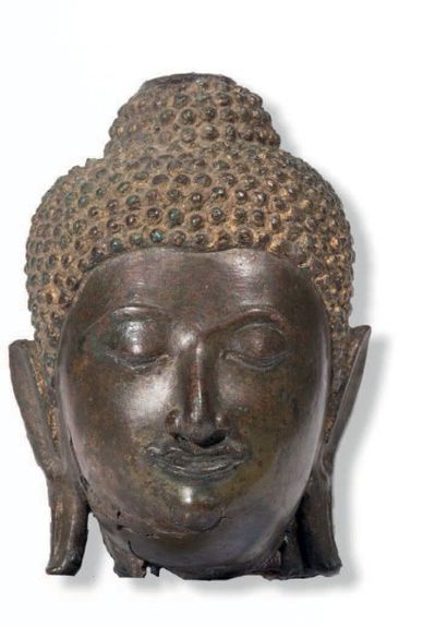 THAILANDE - XVIIE SIÈCLE 
Tête de bouddha en bronze à patine brun rouge, les yeux...