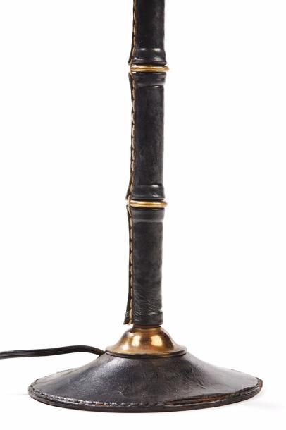 JACQUES ADNET (1900-1981) 
Lampe en métal tubulaire entièrement gainée de cuir noir...