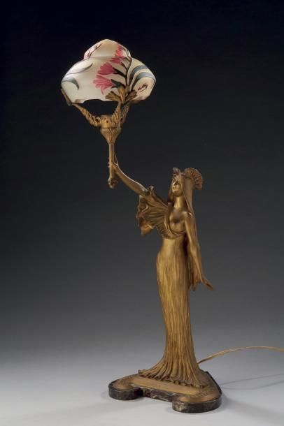 Louis CHALON (1866-1940) Lampe en bronze doré figurant une femme. Elle présente un...