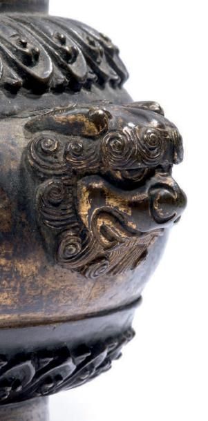 CHINE - XVIIe siècle Brûle-parfum en bronze doré, à deux anses en forme de têtes...