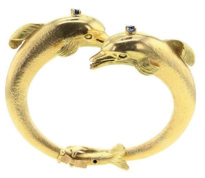 null Bracelet jonc ouvrant en or jaune 18K (750°/00) formé de deux dauphins sertis...