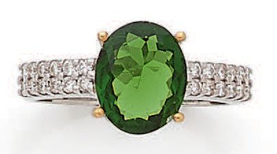 null Bague en or blanc 18K (750°/00) sertie d'une diopside t.ovale épaulée de diamants...