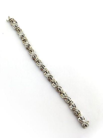 null Bracelet motifs d'entrelacs en or gris 14K (585°/00) orné de diamants t. baguette.
L:...