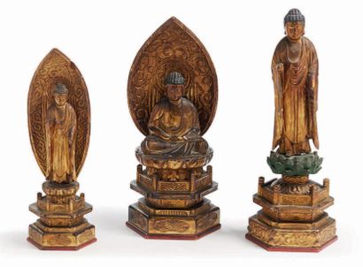 JAPON - XIXE SIÈCLE Trois statuettes de bouddha en bois laqué or, l'un assis formant...