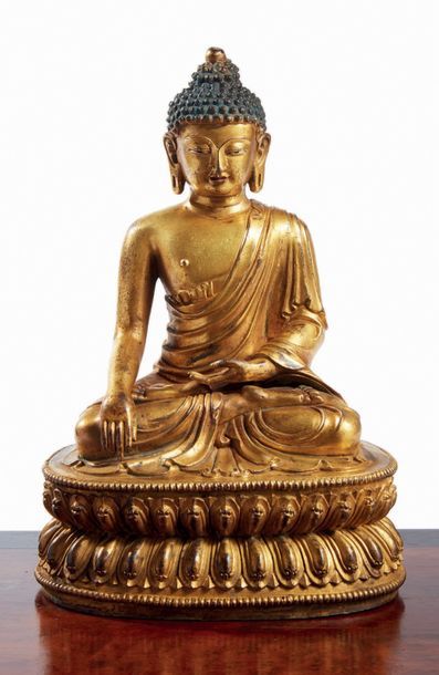 TIBET - XVIIe siècle Statuette de bouddha en bronze doré, assis en padmasa­na sur...