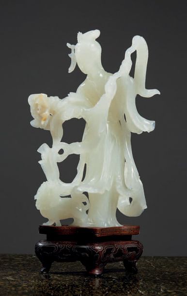 CHINE - Début XXe siècle Statuette de jeune femme debout en néphrite blanche tenant...