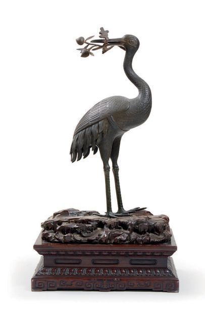 CHINE - XIXe siècle Grande grue posée en bronze à patine brune, la tête retournée...
