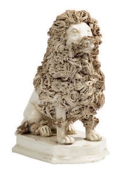 MIDI (?) Statuette figurant un lion blanc en faïence fine assis sur une base rectangulaire,...