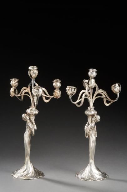 WMF 
Paire de chandeliers en métal argenté à fût figurant une femme nue surmonté...