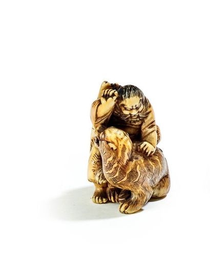 JAPON - XIXE SIÈCLE 
Netsuke in ivory, sennin subduing a tiger with his sword in...