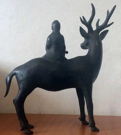 null Statuette en bronze patiné, représentant un cervidé portant un personnage sur...