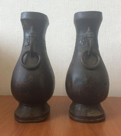 null Paire de vases balustre à patine sombre présentant deux anses à têtes d'animaux...