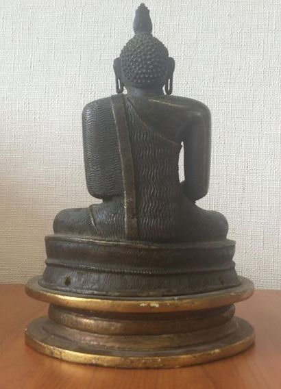null Bouddha en bronze ciselé, patiné et doré assis en tailleur
H. 19,5 cm