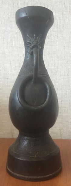 null Vase en bronze  balustre à patine sombre présentant deux anses à têtes d'animaux...