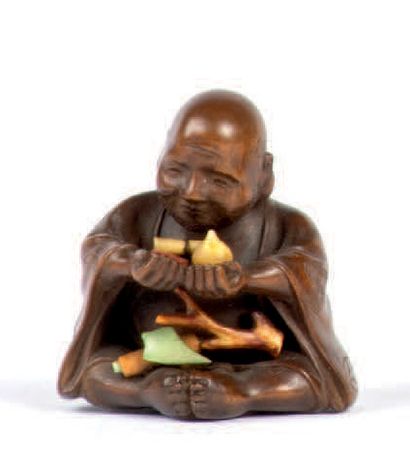 Milieu XXe siècle * Netsuke en bois représentant un homme assis tenant des objets...