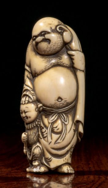 Époque EDO (1603 - 1868) * Netsuke en ivoire, Hotei debout por­tant son sac, la main...