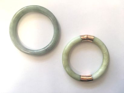 null Deux bracelets joncs jade jadéite dont l'un doté d'une monture en or rose 18K...