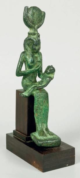 EGYPTE Figurine en bronze à patine verte et rouge de la Déesse Isis, trônant, elle...
