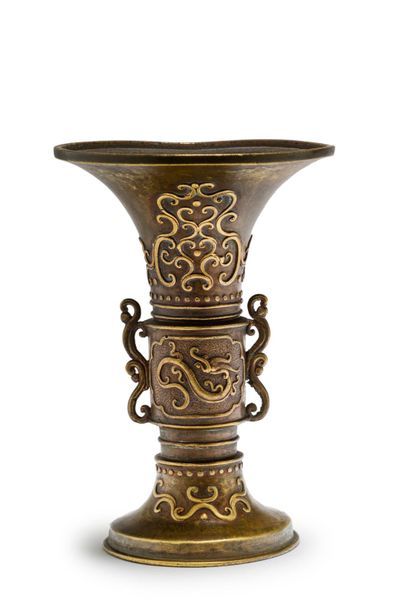 JAPON Vase de forme gu en bronze à dé­cor en relief de chilong et de motifs géométriques....