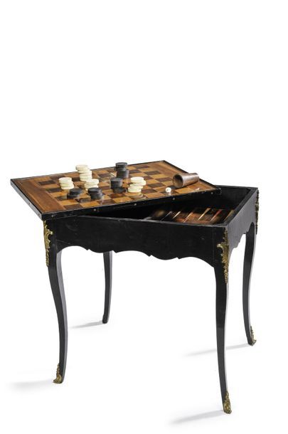  Table à jeux rectangulaire en bois noirci et bois de placage. Le plateau mobile...