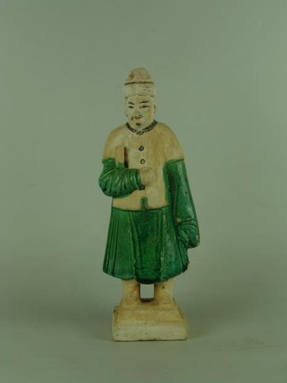 MING (1368 - 1644) Personnage debout sur une base. En terre cuite à glaçure verte....
