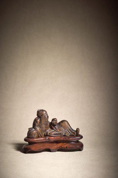 CHINE - XVIIe/XVIIIe siècle ◆ Statuette d'immortel en bois, adossé à une pêche et...
