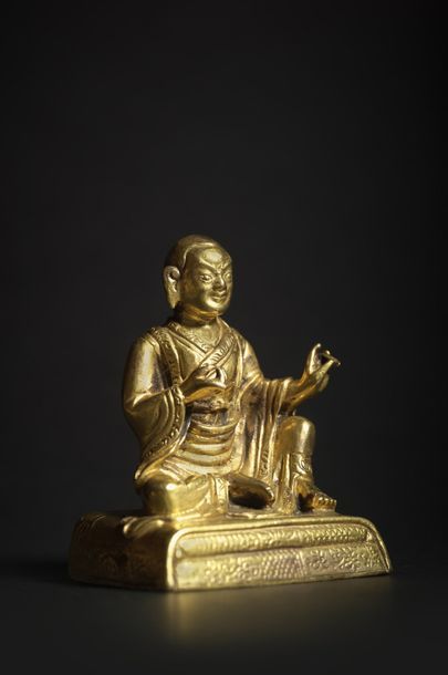 TIBET - XVIIIe siècle Statuette de lhama en bronze doré, assis en lilasana sur un...