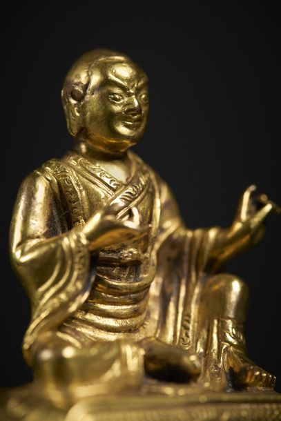 TIBET - XVIIIe siècle Statuette de lhama en bronze doré, assis en lilasana sur un...