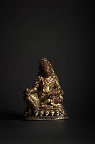 NEPAL - XIIIe/XIVe siècle ◆ Statuette de Jambhala en bronze doré, assis en rajalilasana...