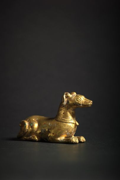 CHINE - Epoque SONG (960 - 1279) Statuette de lévrier couché en bronze doré, portant...
