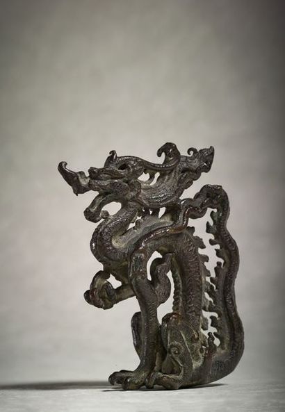 CHINE ● Ornement en bronze en forme de dragon debout, la patte antérieure gauche...