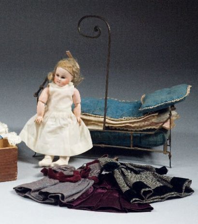 null Poupée tête en porcelaine avec garde robe, lit et literie, vers 1900. H 21 ...