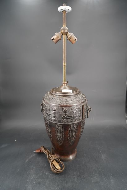 null Un vase monté en lampe en bronze patiné à décor en relief de caractères chinois,...
