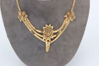 null Set in pink gold comprising a drapery necklace adorned with flowers centered...