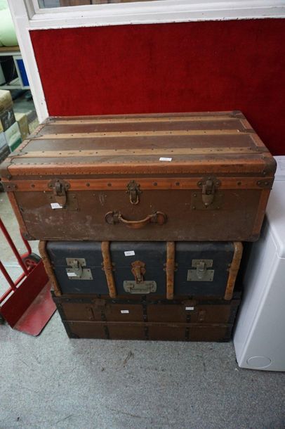 null Reunion of three travel trunks, one of which is a leather jacket.
