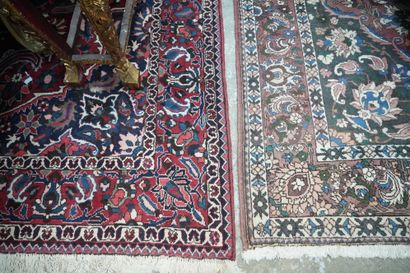 null Deux grands tapis en laine à fond rouge et à décor de fleurs.