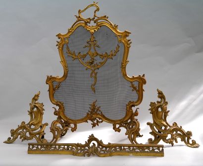 null 一个罗盖尔形的鎏金青铜屏风，装饰着丝带、叶子、蝴蝶和花朵，站在四个蜿蜒的镂空腿上。- 拿破仑三世时期，路易十五风格。- 高度：80厘米 - 宽度：58.5厘米...