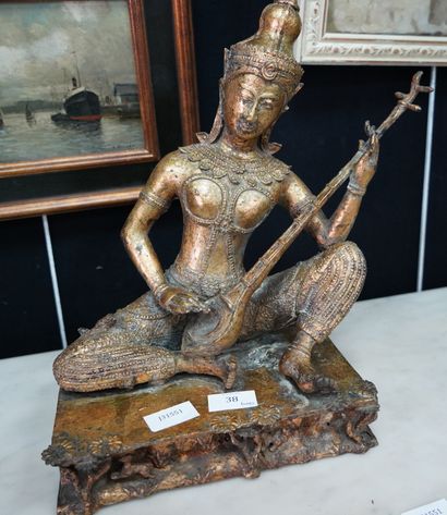 null Sujet en bronze doré figurant un personnage jouant de la cithare indienne.