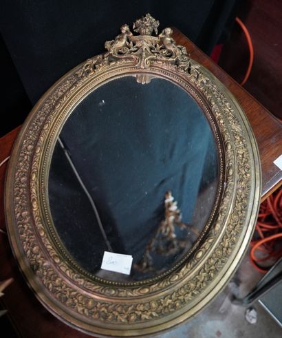 null Un miroir ovale dans un encadrement en bois et stuc doré. On joint un miroir...