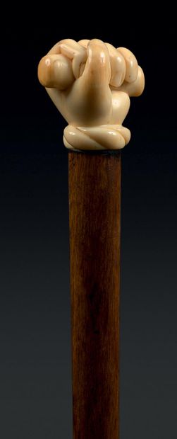 CANNE HISTORIQUE La poignée en ivoire sculpté d'une main tenant un rouleau de parchemin...