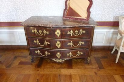 null Commode sinueuse en bois plaqué et cannelures de laiton, ouvrant par trois tiroirs....