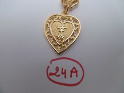Chaine de cou Chaîne de cou retenant un pendentif en forme de cœur gravé de caractères...