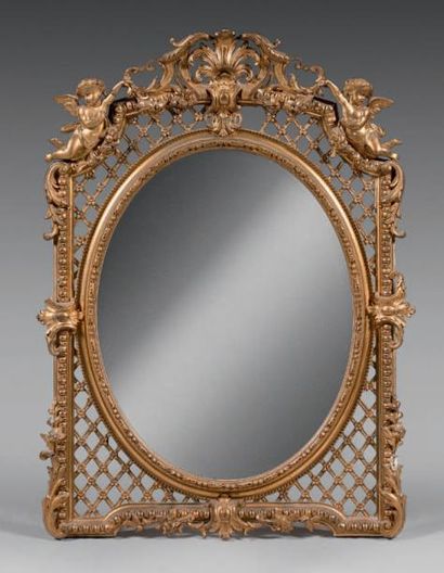 null Miroir en bois et composition dorée, s'inscrivant dans un ovale perlé, le pourtour...