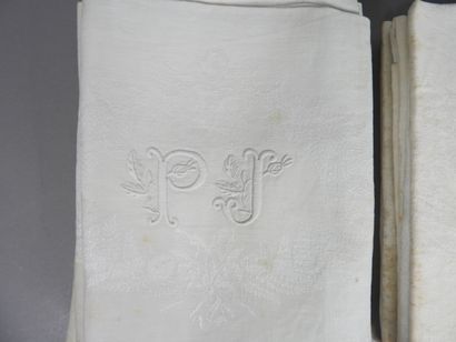 null 12 serviettes chiffrées P J en Damas blanc à décor de couronnes de feuillage....