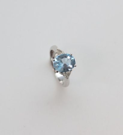 null Bague en or gris 750°/°° serti d'une topaze bleue traitée épaulée de deux diamants...