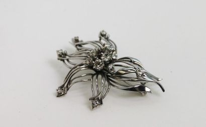 null Broche en or gris 750°/°° en forme de fleur stylisée ornée de diamants taille...
