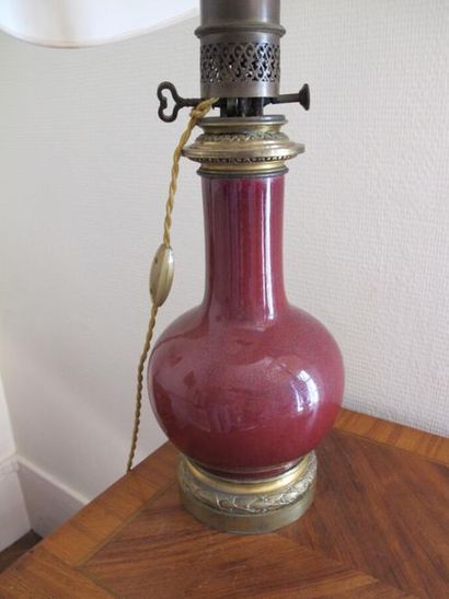 null Vase en porcelaine rouge sang de boeuf monté en lampe à huileH. 35 cm . 
On...