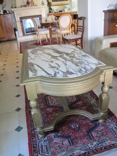 null Table basse bois mouluré et sculpté peint or, dessus de marbre blanc veiné....