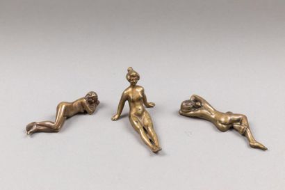 null Trois sujets en bronze ciselé et doré représentants des jeunes filles nues allongées.
Début...